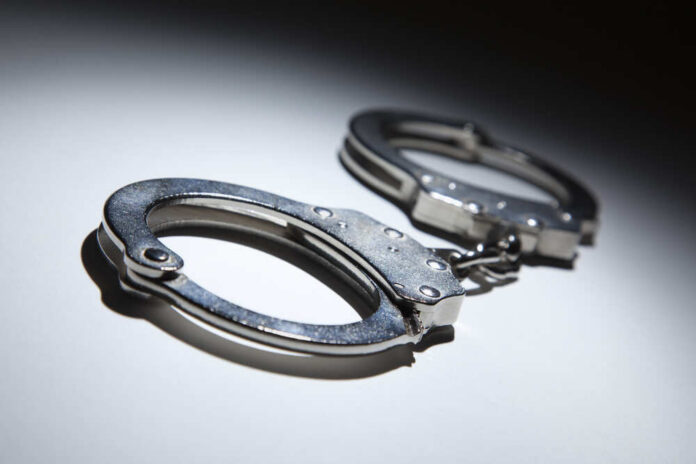 Close-up of metallic handcuffs on a light surface