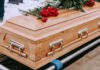 Wooden casket with red roses on top