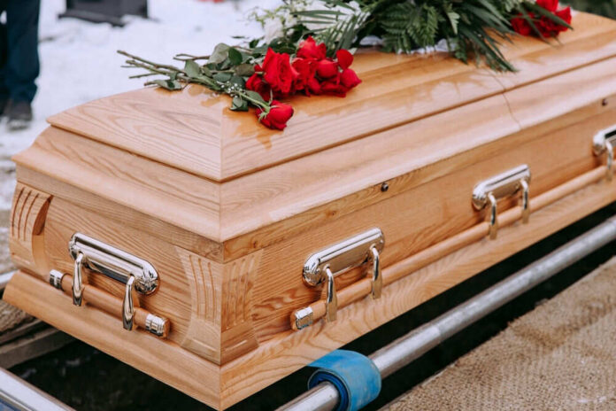 Wooden casket with red roses on top