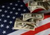 Massive Fraud Payouts: See What You Could Earn! Dollar bills arranged on an American flag