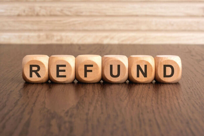 Wooden blocks spelling refund on table