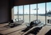 View of an airport waiting area with an airplane taking off in the background