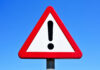 Red-Light Speeder Slams TV Star and Children A triangular warning sign with an exclamation mark against a blue sky