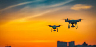 Two drones flying during colorful sunset skyline