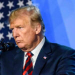 Trump’s Walter Reed Visit Raises Questions Donald Trump speaks at a podium.