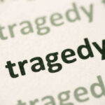Close-up of the word 'tragedy' printed multiple times in varying shades