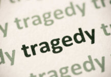 Close-up of the word 'tragedy' printed multiple times in varying shades