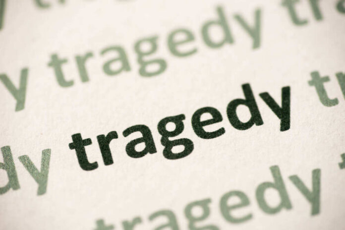 Close-up of the word 'tragedy' printed multiple times in varying shades