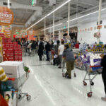 Customers waiting in line at a supermarket checkout.