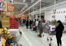 Customers waiting in line at a supermarket checkout.