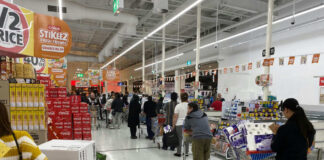 Customers waiting in line at a supermarket checkout.
