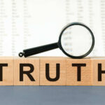 DARK Espionage Execution: What They’re Hiding Wooden blocks spelling truth with magnifying glass