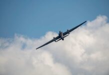 Military aircraft flying against a cloudy sky