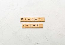 Wooden letter tiles spelling 'Product recall' on a textured surface