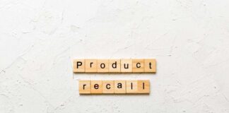 Wooden letter tiles spelling 'Product recall' on a textured surface