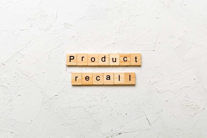 Wooden letter tiles spelling 'Product recall' on a textured surface