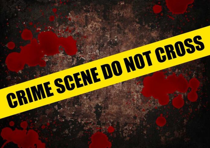 shutterstock_2559703967.jpg Yellow caution tape reading 'CRIME SCENE DO NOT CROSS' over a dark, blood-splattered background