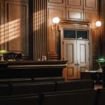 Interior of a courtroom with wooden paneling and green desk lamp