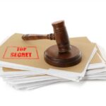 Judge’s gavel resting on a stack of confidential files