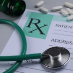 A prescription pad with a stethoscope and pills nearby