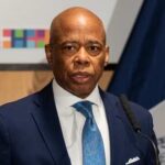 A man in a suit speaking at a podium