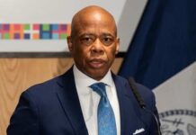 A man in a suit speaking at a podium