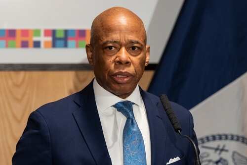 A man in a suit speaking at a podium