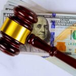 Judge’s gavel on a stack of U.S. hundred-dollar bills