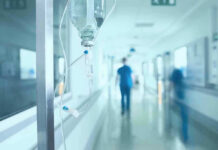 Miracle Pill? Read The Fine Print Hospital corridor with IV drip and healthcare worker.