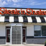 Exterior view of a Steak 'n Shake restaurant with a striped awning