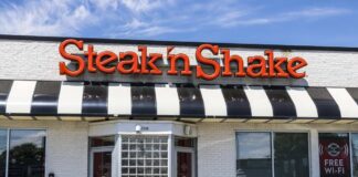 Exterior view of a Steak 'n Shake restaurant with a striped awning