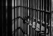 Black and white prison cell bars in dim light.