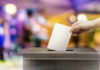Judge SLAMS Voter Database — Halted Hand placing ballot in voting box.