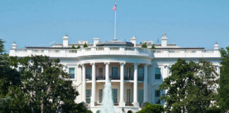 The White House, front view with fountain and flag.