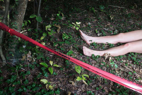 Bare feet visible near caution tape in a wooded area