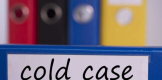 Blue binder labeled 'cold case' with other colored binders in the background