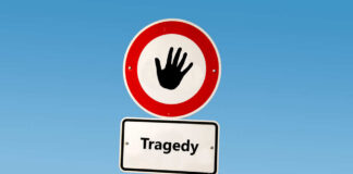 Road sign with hand stop symbol and a lower sign reading Tragedy