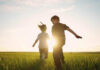Children running in a field at sunset.