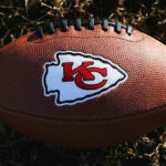 Kansas City Chiefs football lying on the grass.