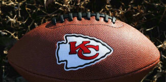 Kansas City Chiefs football lying on the grass.