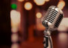 Vintage microphone on a blurred, warm-toned background.