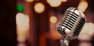 Vintage microphone on a blurred, warm-toned background.