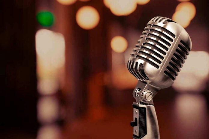 Vintage microphone on a blurred, warm-toned background.