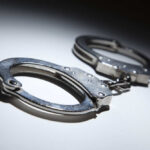 Close-up of metallic handcuffs on a light surface