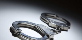 Close-up of metallic handcuffs on a light surface