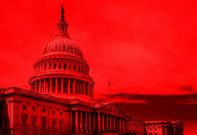 United States Capitol building under red-tinted sky.