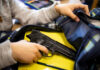 Kid placing handgun inside a backpack on desk