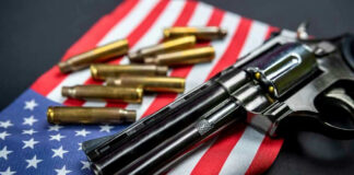 Revolver and bullets on American flag background.