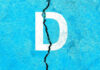 White letter D on cracked blue surface.