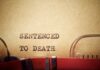 Typewriter typing the phrase 'Sentenced to Death' on aged paper